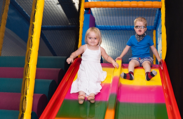 two children going down colourful slide