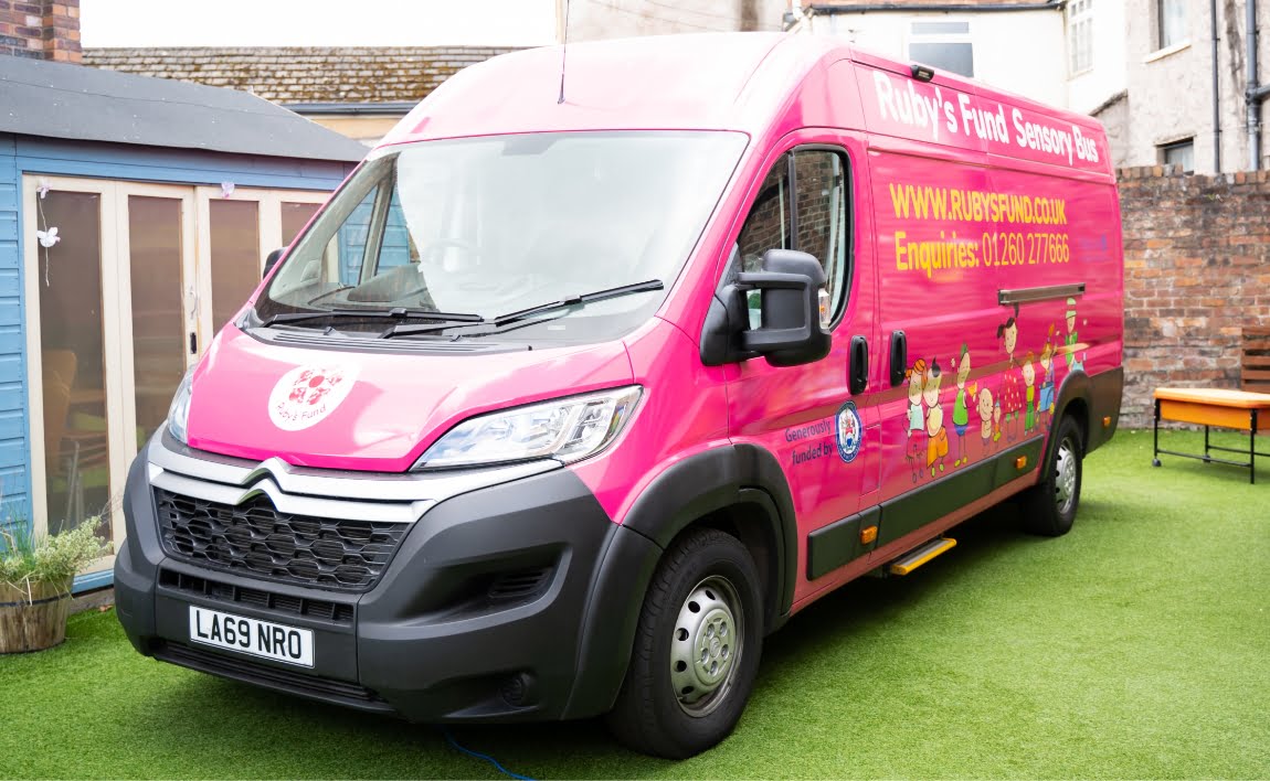 our big pink sensory bus parked on green astro turf